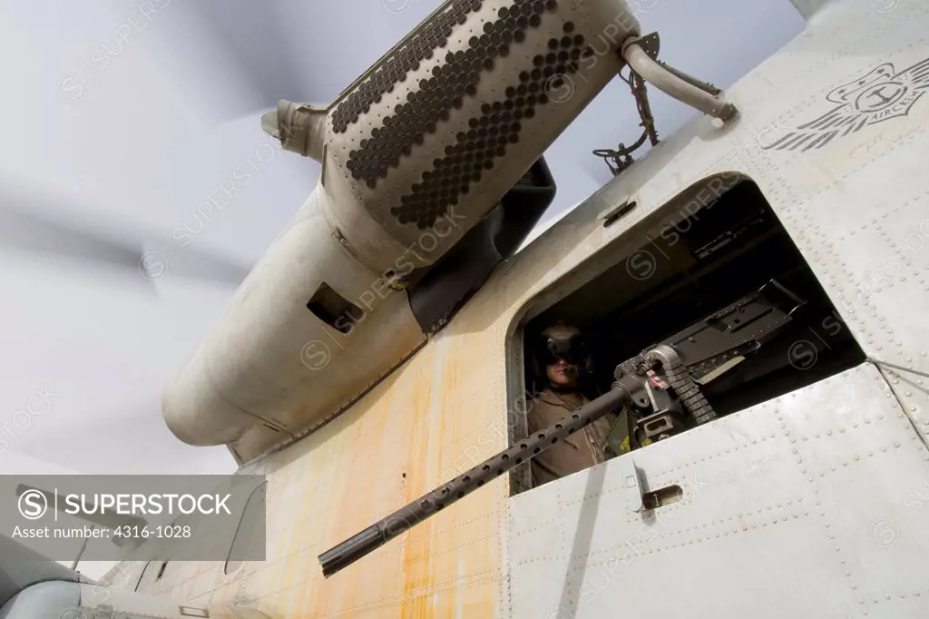 A US Marine Corps Door Gunner Peers from a CH-53D Sea Stallion Helicopter from Above an M2 .50 Caliber Machine Gun