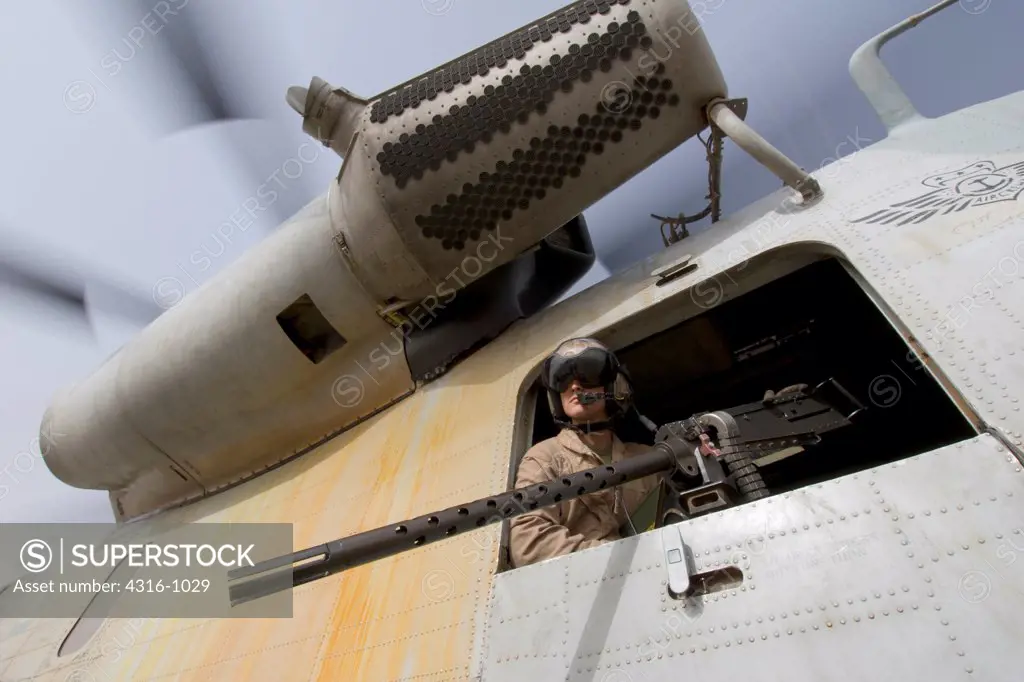 A US Marine Door Gunner Peers from a CH-53D Sea Stallion Helicopter from Above an M2 .50 Caliber Machine Gun