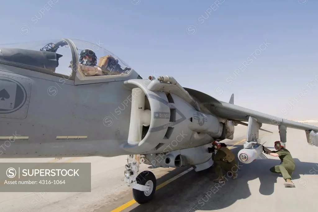 A US Marine Arms a Laser Maverick Air to Ground Missile Mounted on an AV-8B Harrier Ready to Launch from Al Asad Air Base in Iraq's Al Anbar Province