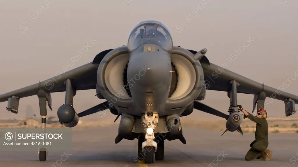 A Ground Crewman Arms Weapons on a US Marine Corps AV-8B Harrier at Al Asad Air Base in the Al Anbar Province of Iraq