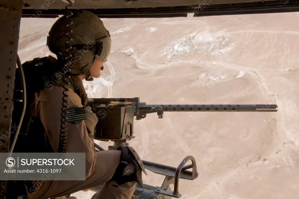 A US Marine Corps Door Gunner Scans the Landscape South of Haditha, Iraq, From Behind an M2 .50 Caliber Machine Gun During a Close Air Support Mission