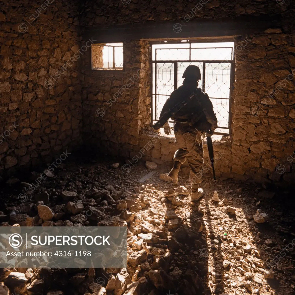 A US Marine Searches an Abandoned House for Hidden Explosives and Weapons in the City of Haditha, in Iraq's Anbar Province