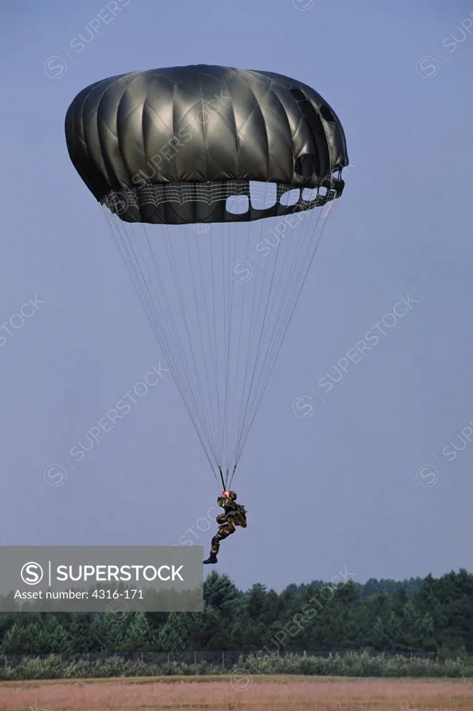 Military Parachutist Prepares to Land