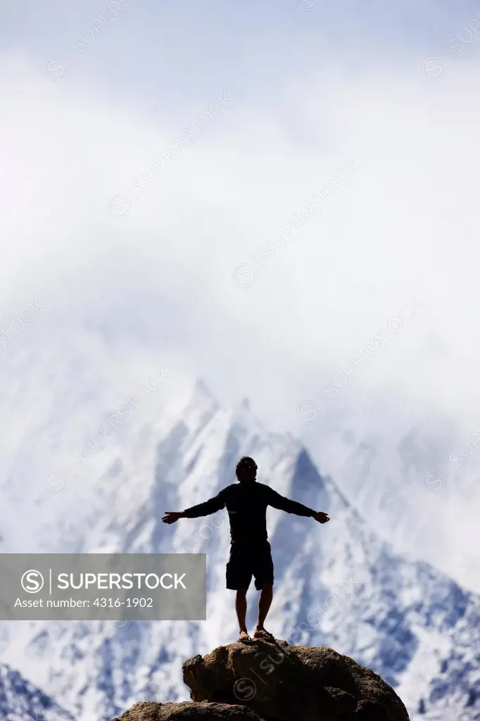 Climber Basks in the Sunny Mountain Air After Ascending a Sheer Face of a Boulder