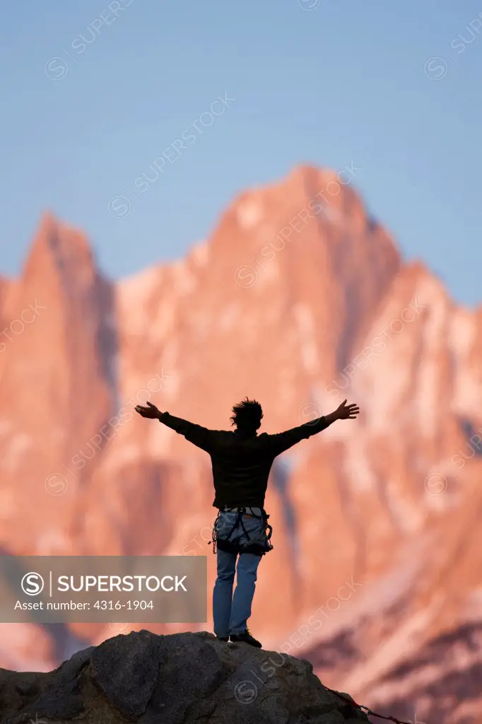 A Climber Enthusiastically Welcomes The Dawn of a New Day Atop a Boulder in California's Alabama Hills, Mount Whitney and Surrounding High Sierra Peaks in Distance