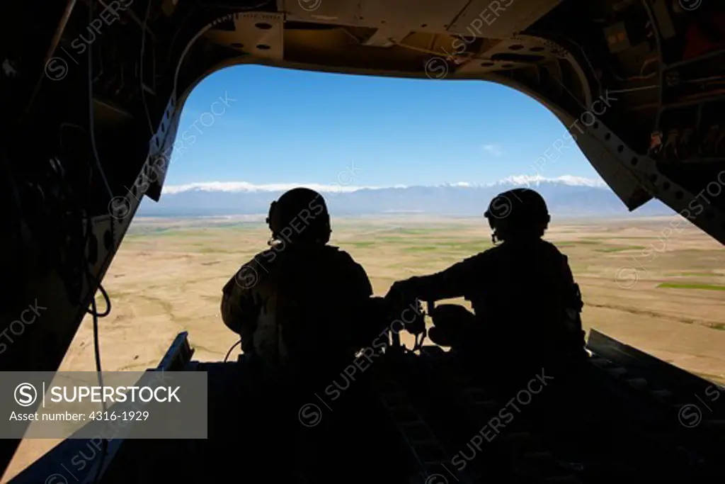 Army Air Crew Silhouetted in the Back of a CH-47 Chinook Flying Toward Kabul