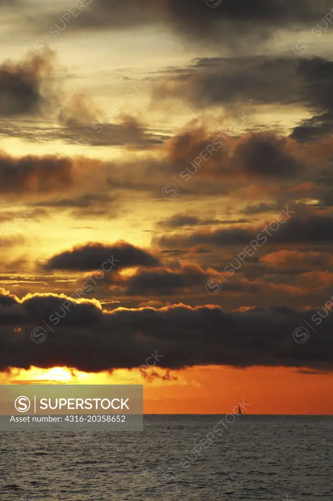 Sunrise and distant sailboat, clouds, Strait of Malacca
