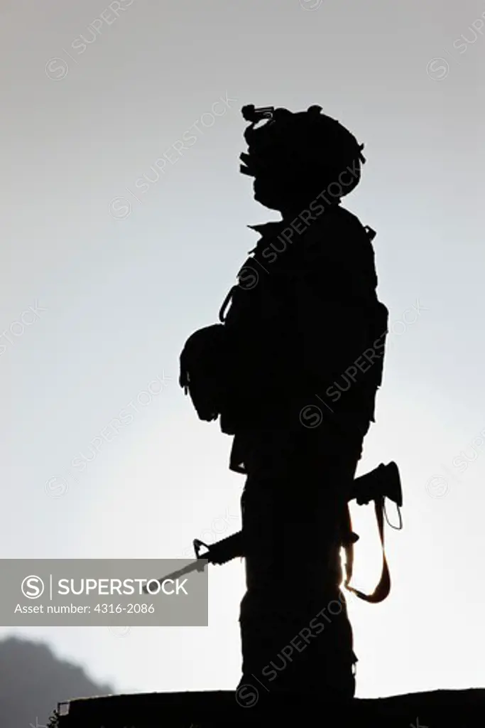 U.S. Army Soldier Holding His Weapon at Sunrise