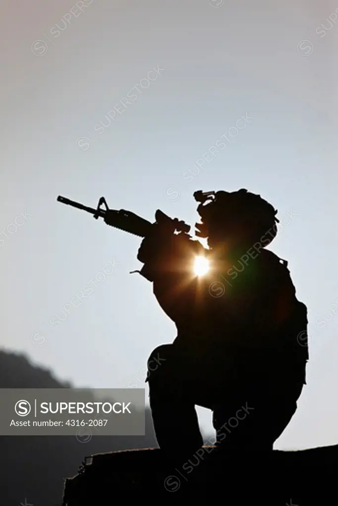 U.S. Army Soldier Holding His Weapon at Sunrise