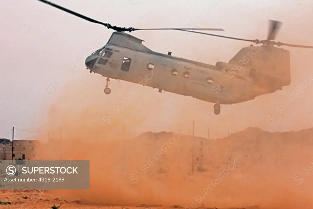 A US Marine Corps CH-46 Sea Knight Makes A Dusty Approach On A Desert Helicopter Landing Zone