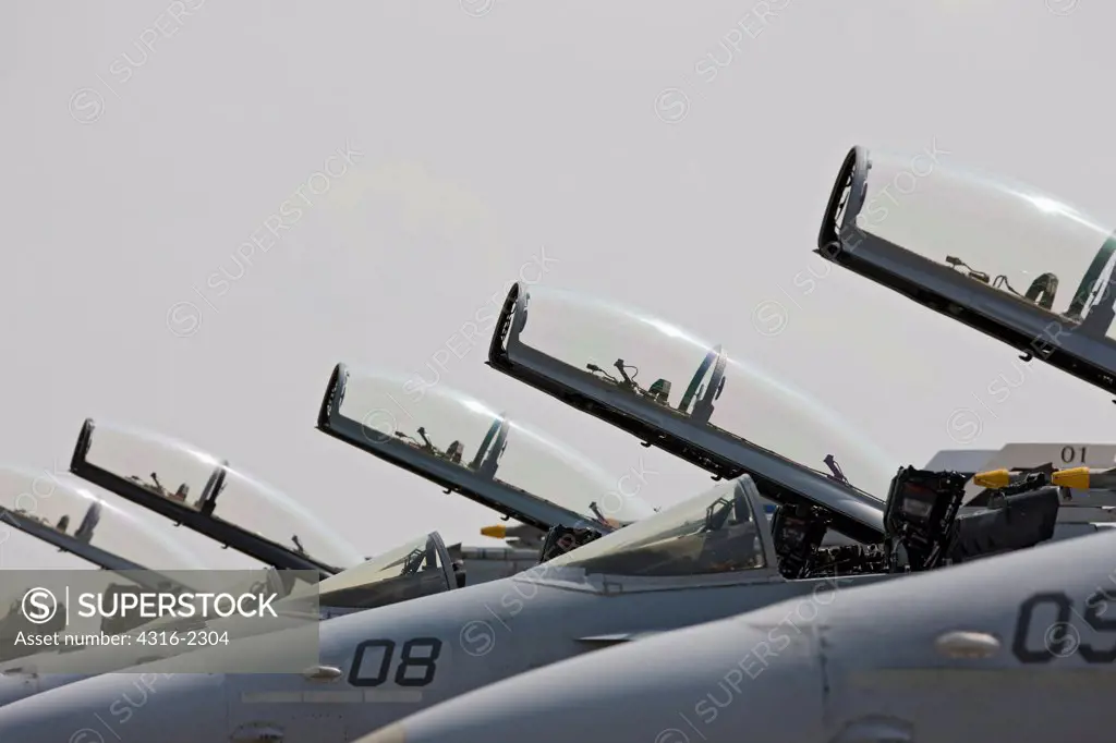 Open cockpits of lined-up United States Marine Corps F/A-18D Hornets at Kuantan Air Base, Malaysia.