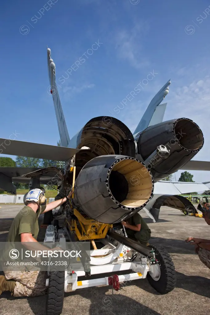 United States Marine Corps aircraft maintainers install a new engine on an F/A-18D Hornet at Kuantan Air Base, Malaysia.