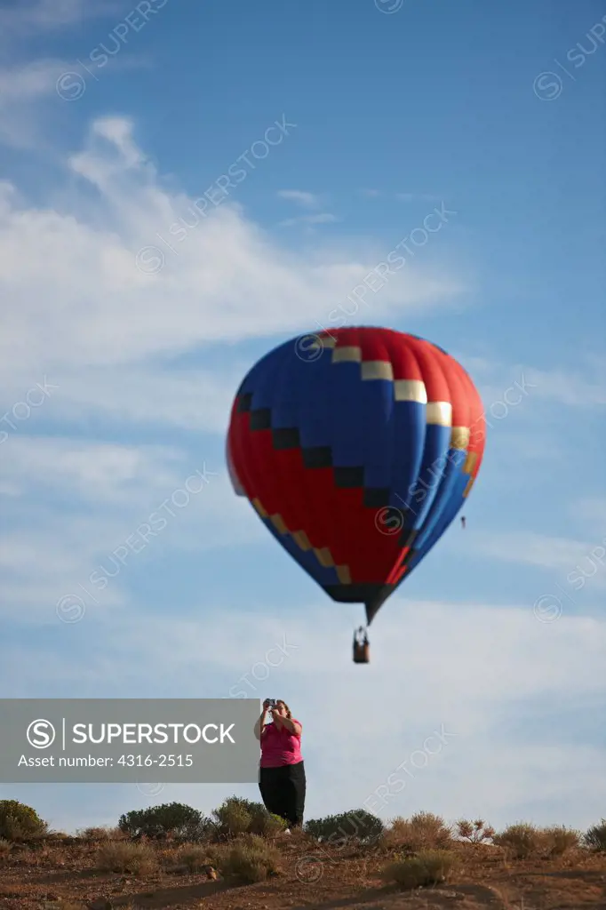 A hot air balloon floats above a balloon enthusiast during the Reno Balloon Races, Reno, Nevada.