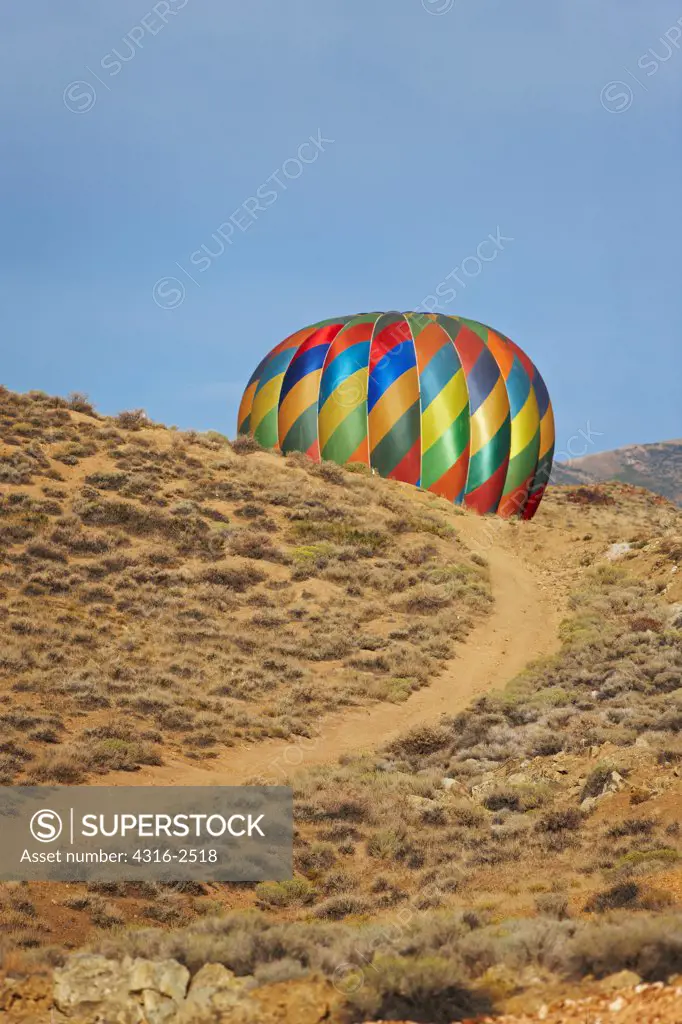 A dirt road winds toward a deflating hot air balloon, Reno Balloon Races, Reno, Nevada