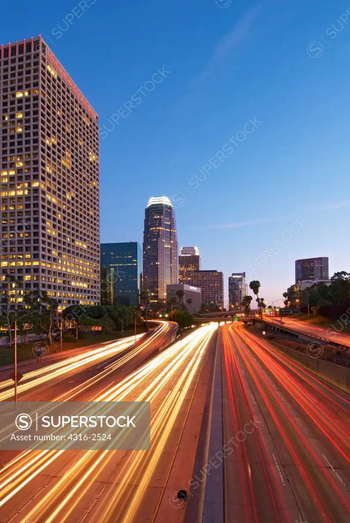 Interstate 110 strikes through downtown Los Angeles. A time exposure captures the dusk light as well as the streaks of light of passing cars