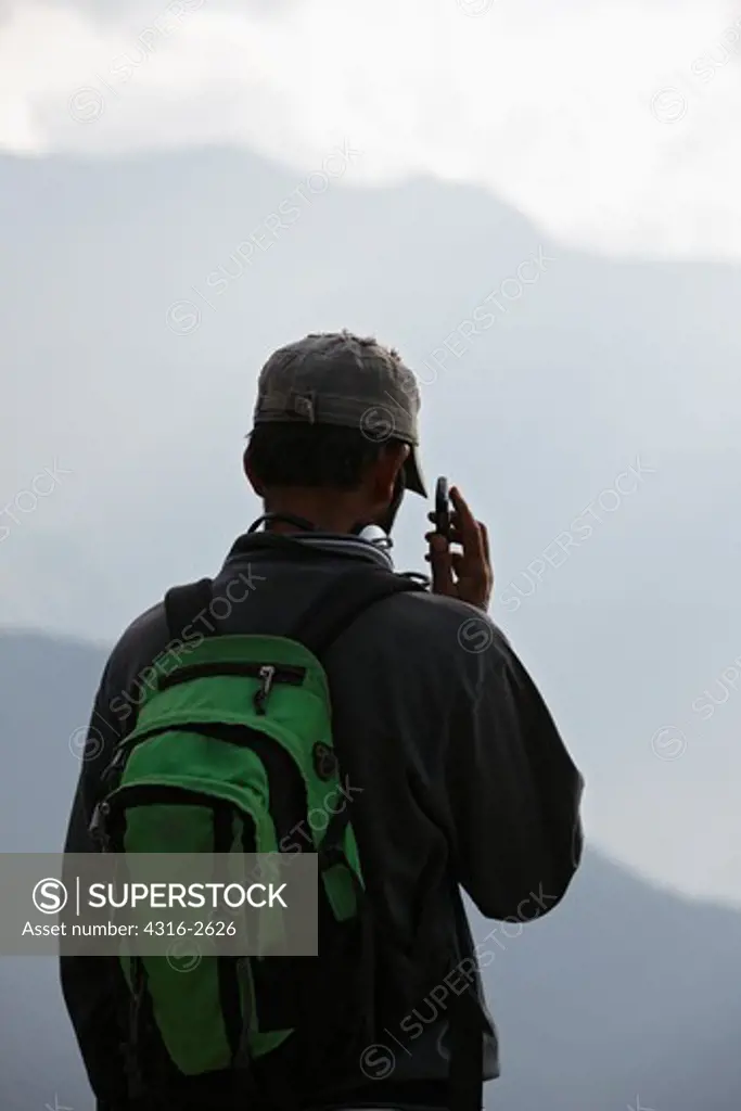 Man with Cellular Phone in the Foothills of the Himalayas