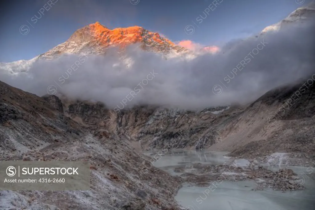 A high dynamic range image of Makalu and a small glacial lake (tarn) below the peak's bulk. Makalu is the fifth highest mountain in the world, at 27,766 feet (8,465 meters) above mean sea level.