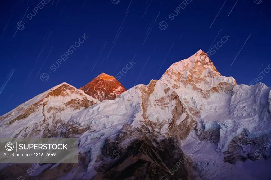 View of Mount Everest and Nuptse with the last of the day's light and stars above.