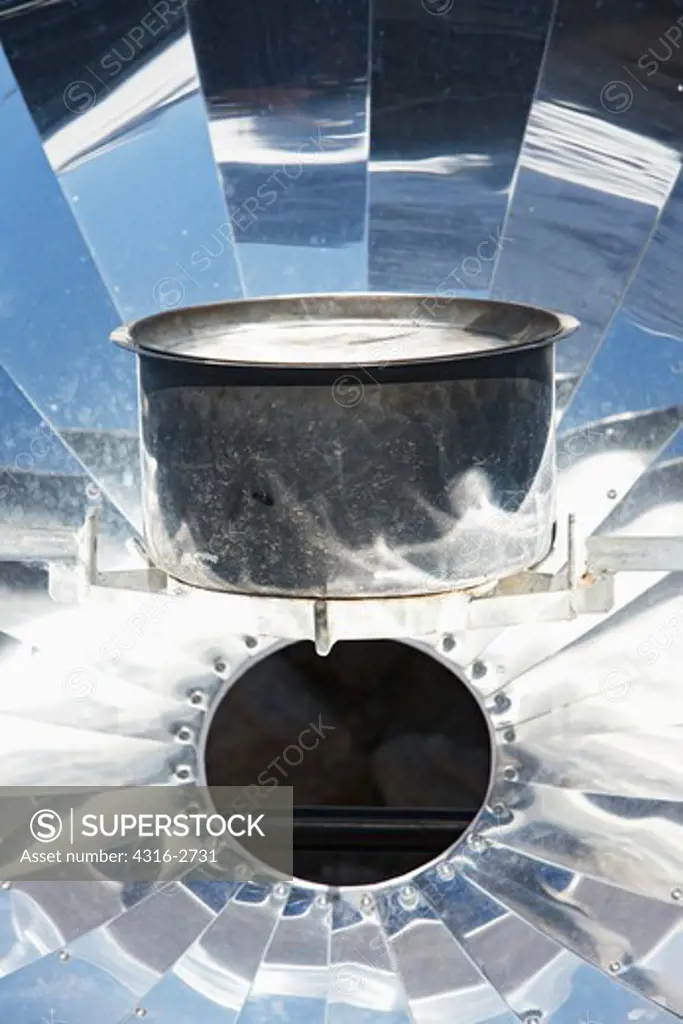 A parabolic solar water heater heats a bowl of water in the Mount Everest region, Nepal.