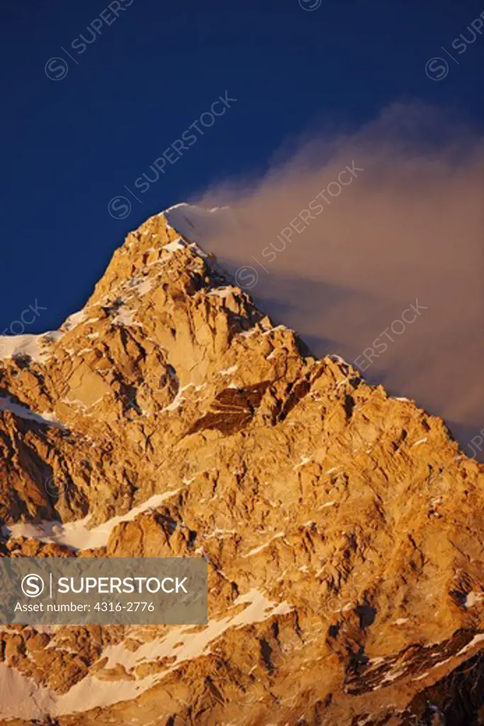 Image of the West Face of Makalu, the world's fifth highest mountain at 27,766 Feet (8,465 Meters) above mean sea level. The image was made at sunset, with alpenglow on the massive wall as extreme winds lift a banner cloud off the lee side of the peak. Makalu lies in the Everest region of Nepal.