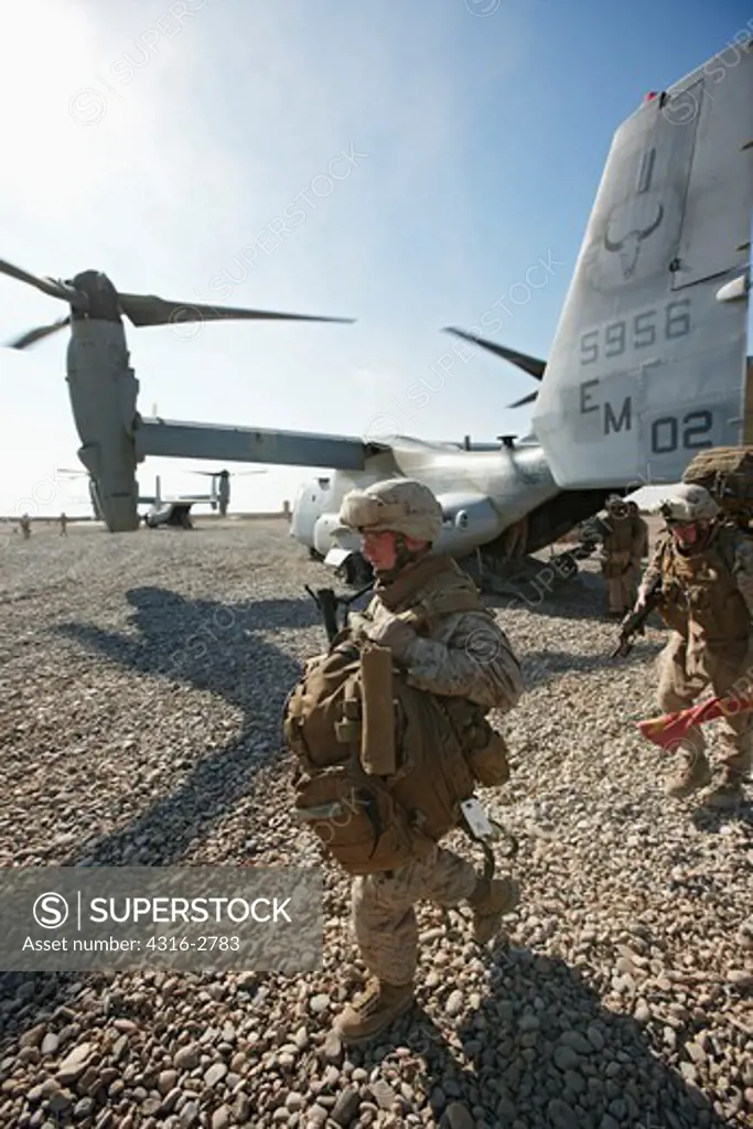 A U.S. Marine offloads gear from an MV-22 Osprey after landing at a combat outpost in the Helmand Province of southern Afghanistan.