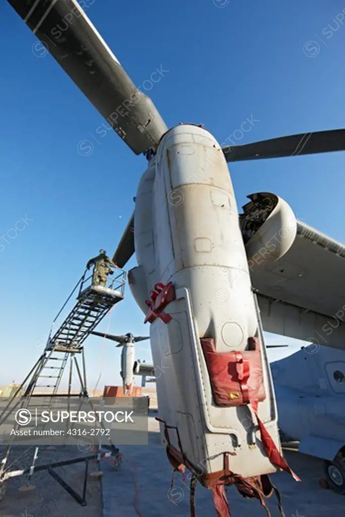 U.S. Marine Corps aircraft maintainer works on a proprotor assembly of an MV-22 Osprey, Camp Bastion, Helmand Province of southern Afghanistan.