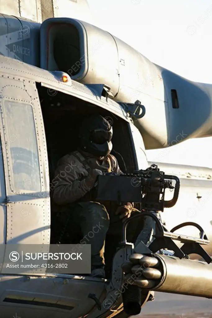A U.S. Marine door gunner awaits launch of a U.S. Marine Corps UH-1Y Venom at Camp Bastion, Helmand Province, Afghanistan