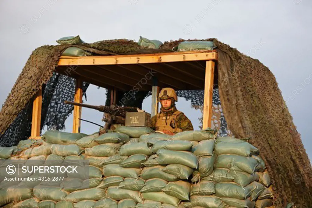 A U.S. Marine stands guard at a combat outpost behind a .50 caliber machine gun in southern Afghanistan's Helmand Province.