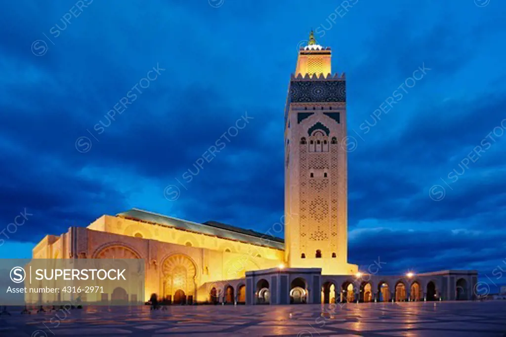 Dusk view of the Hassan II Mosque. The minaret is the tallest in the world at 210 meters high. The laser on the upper minaret emits a green beam which points towards Mecca. The mosque is the tallest structure in Morocco, and was built on reclaimed land overlooking the Atlantic.
