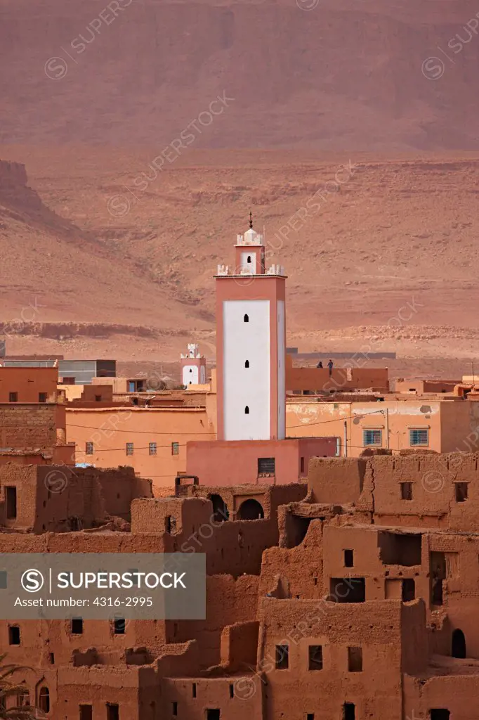 Mosque minaret above earthen dwellings in Tinerhir, Morocco.