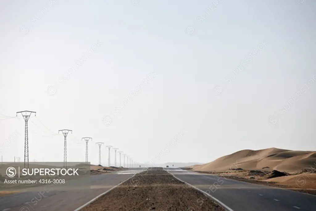 A road strikes through sand dunes in El-Aaiun, Western Sahara.