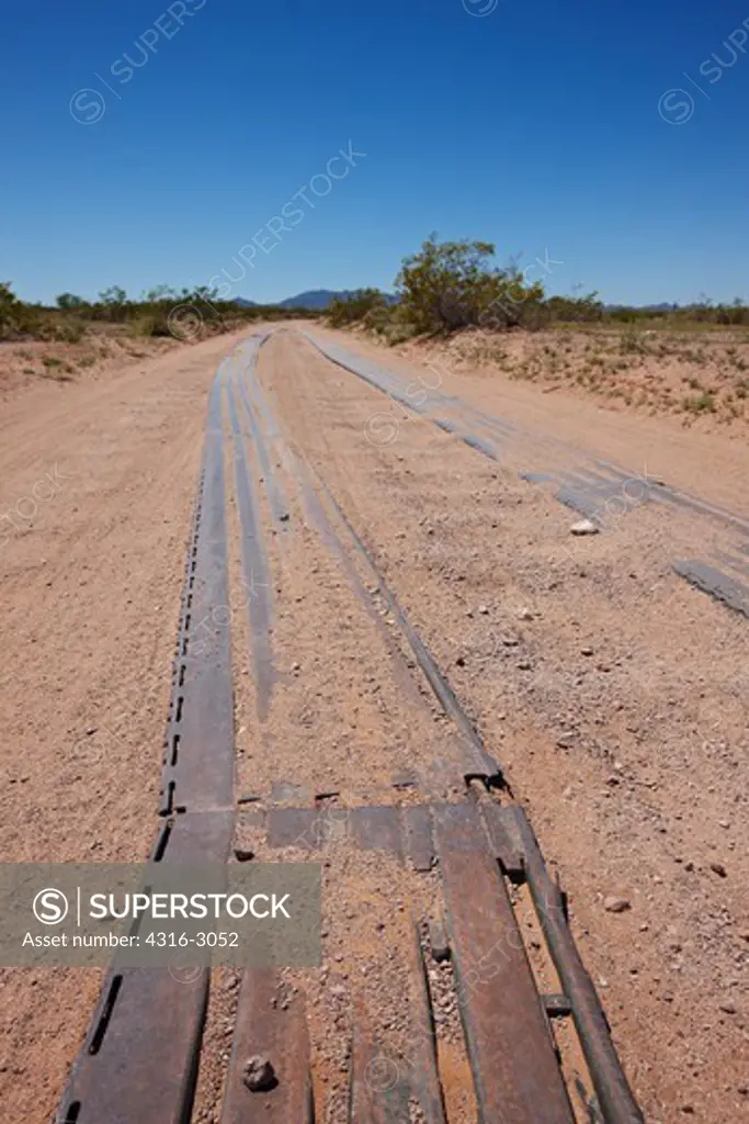 Portions of the Camino Del Diablo, or Highway of the Devil, are reinforced with old portable runway slats to mitigate rutting of the road due to frequent use by U.S. Border Patrol agents.