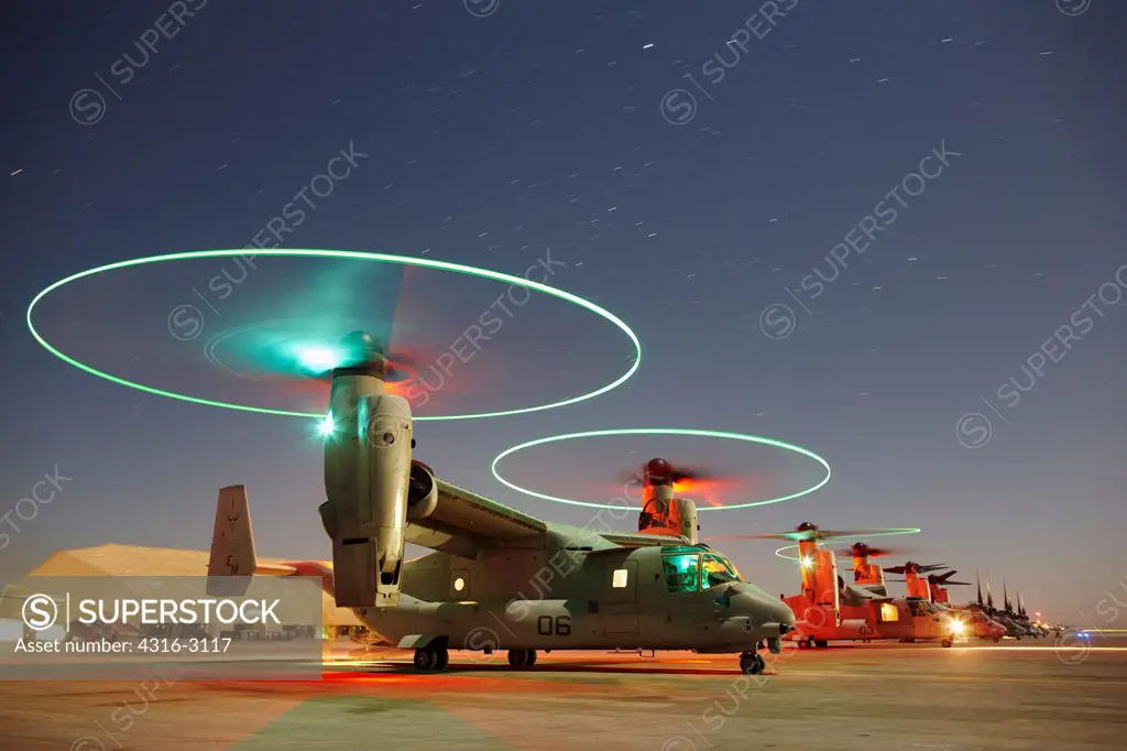 Nighttime View of a line of U.S. Marine Corps MV-22 Ospreys at Camp Bastion, Helmand Province, Southern Afghanistan, With Osprey In Foreground Idling With Proprotor Tip Lights