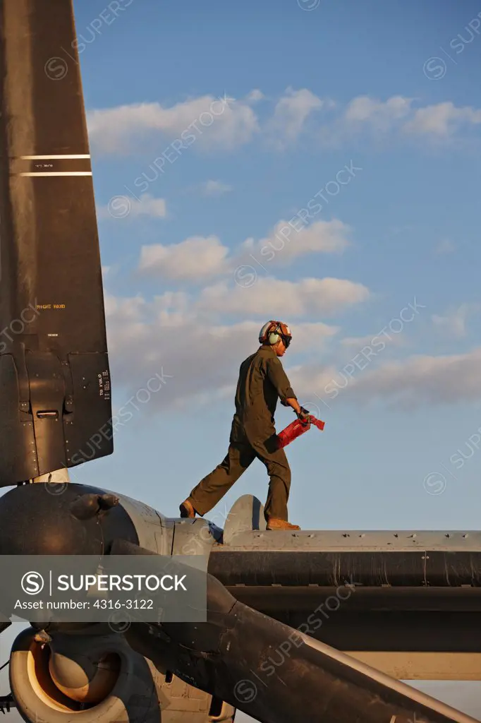 A U.S. Marine Corps aircraft maintainer atop wing of a MV-22 Osprey, Camp Bastion, Helmand Province, southern Afghanistan.