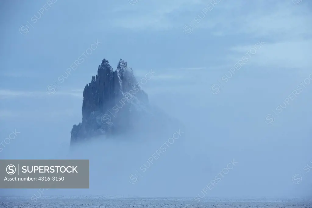 Winter fog shrouds Shiprock, also called Ship Rock, an ancient volcanic plug near Farmington, New Mexico.