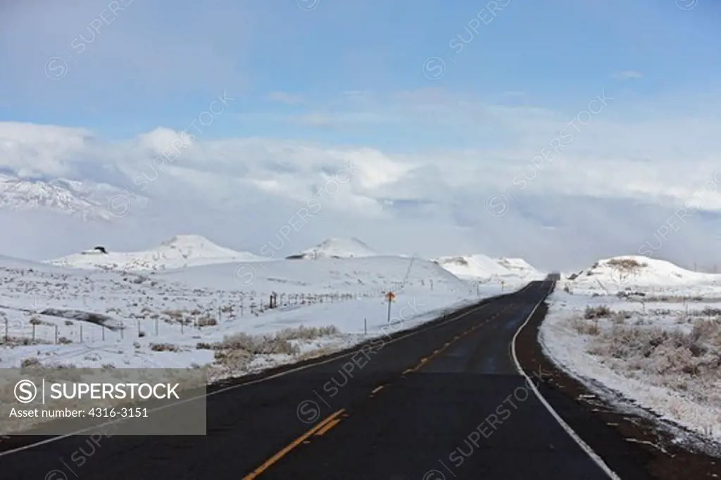 A passing winter storm leaves snow on the ground through which U.S. Highway 64 passes, near Beclabito, New Mexico.