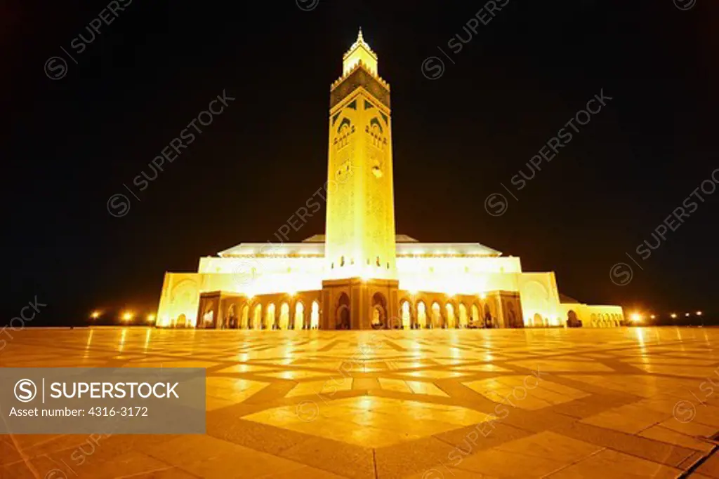 A nighttime view of the Hassan II Mosque in Casablanca. The mosque's minaret is the tallest minaret in the world at 210 meters high. A laser on upper minaret emits a green laser beam toward Mecca. This is the tallest structure in Morocco.
