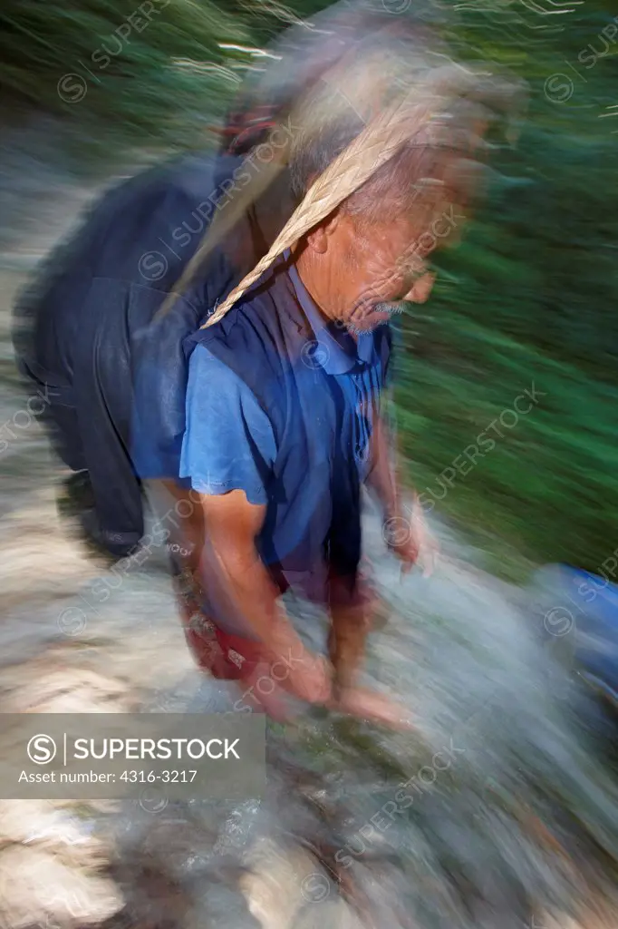 A Nepali man walks down steep trail, near Num Village, Nepal.