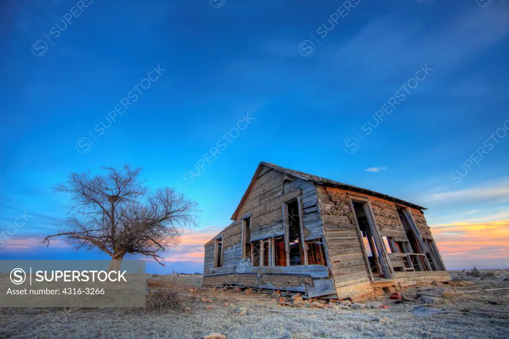 An abandoned farm house and tree on Colorado's Eastern Plains, Dusk, in an HDR, or High Dynamic Range Image.