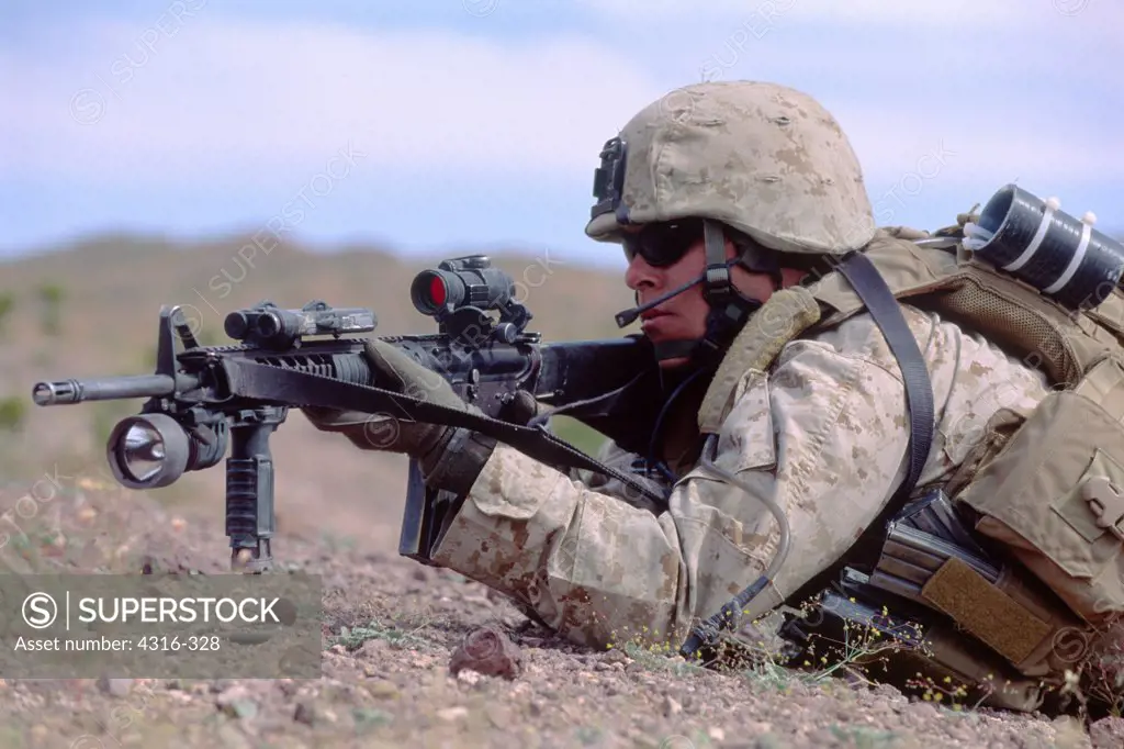 US Marine Crawls Along the Desert Floor During Combat Training