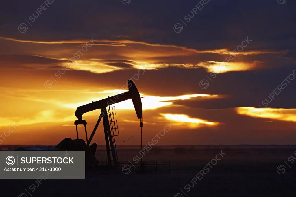 Silhouette of an oil well pump jack on the plains of Colorado.