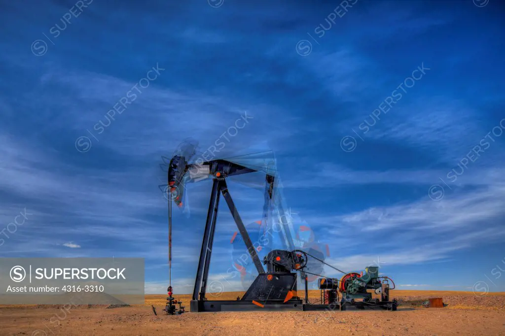 High dynamic range, or HDR, image of an oil well pump jack in northeastern Colorado, showing motion of the pump, the end known as the 'horsehead' (left side), walking beam, crank, and counterweight. A pump jack is also known as a pumpjack, a pumping unit, a grasshopper pump, and a jack pump, among other names.