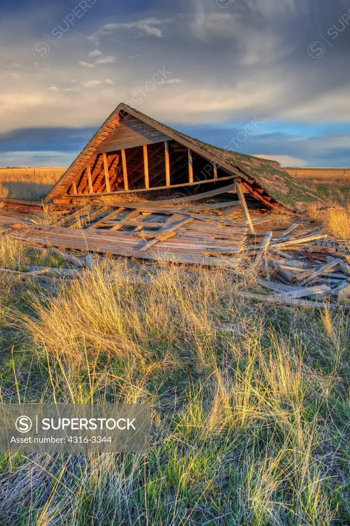 High dynamic range (HDR) image of crumbling farm house where only the roof lies intact, Pawnee National Grasslands, Colorado.