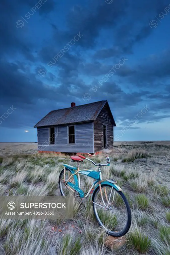A high dynamic range, or HDR image of a 1950s era 'Monark Holiday' bicycle in front of the abandoned school house in  Buckingham, Colorado.