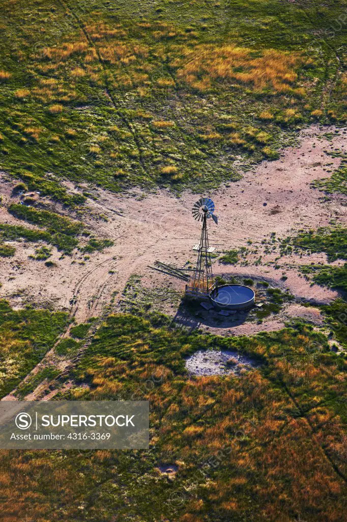 An aerial view of a water-pumping windmill and a cistern for cattle watering, in eastern Colorado.