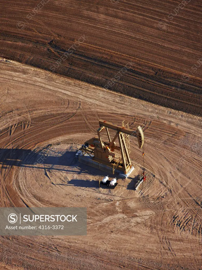 An aerial view of an oil well pump jack, on the plains of eastern Colorado.
