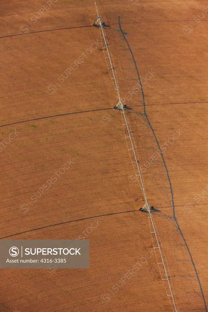 An aerial view of a center pivot irrigation system on bare farm land, on the plains of eastern Colorado.