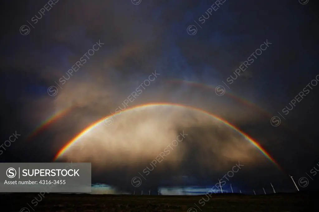 Double rainbow over wind farm and curtain of rain, High Dynamic Range, or HDR image.