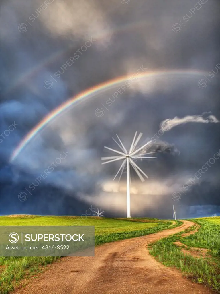 Double rainbow over wind turbine and wind farm, winding road, high dynamic range, or HDR image.