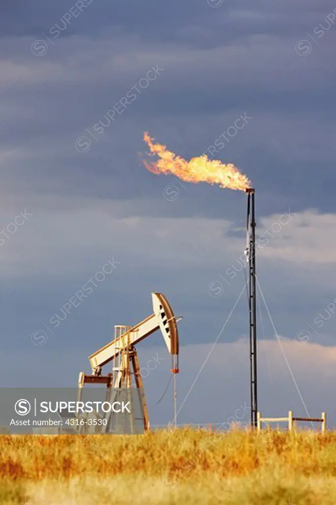 An oil well pump jack and a natural gas flare tower. A pump jack is also known as a pumpjack, a pumping unit, a grasshopper pump, and a jack pump, among other names. A flare tower, also known as a flaring tower, is used to burn off excess natural gas at pump sites.